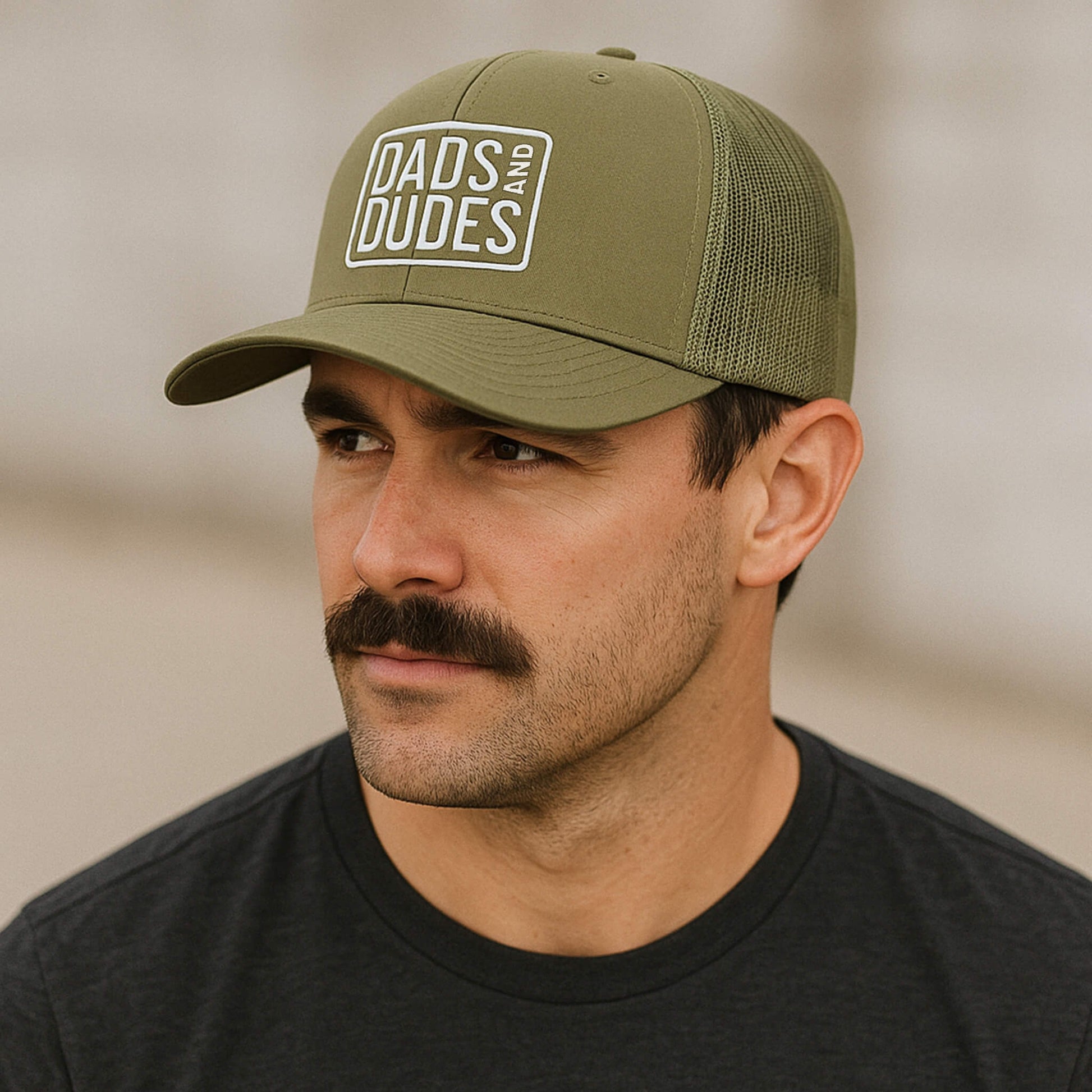 Man wearing Dads And Dudes Green Embroidered Logo Trucker Cap.